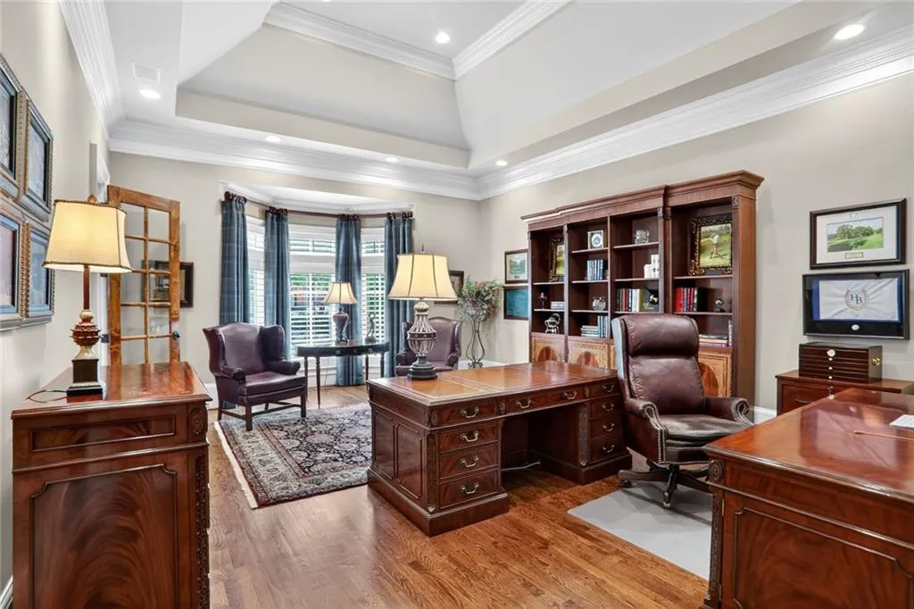 Home office featuring light wood-type flooring, a tray ceiling, ornamental molding, and recessed lighting