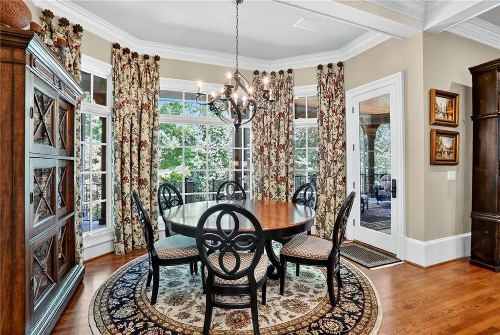 Dining area with crown molding, dark wood-type flooring, and a chandelier