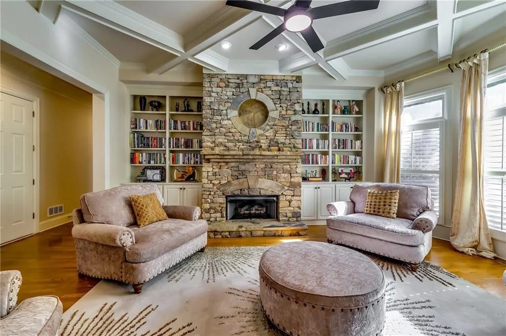 Living room with coffered ceiling, bookshelves, and crown molding.