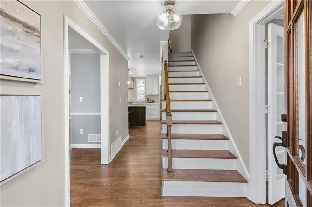 Foyer featuring ornamental molding and dark hardwood / wood-style floors