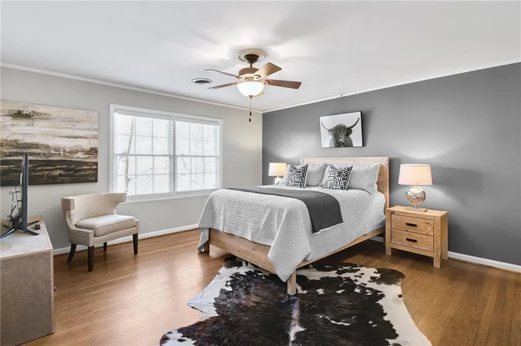 Bedroom featuring crown molding, wood-type flooring, and ceiling fan