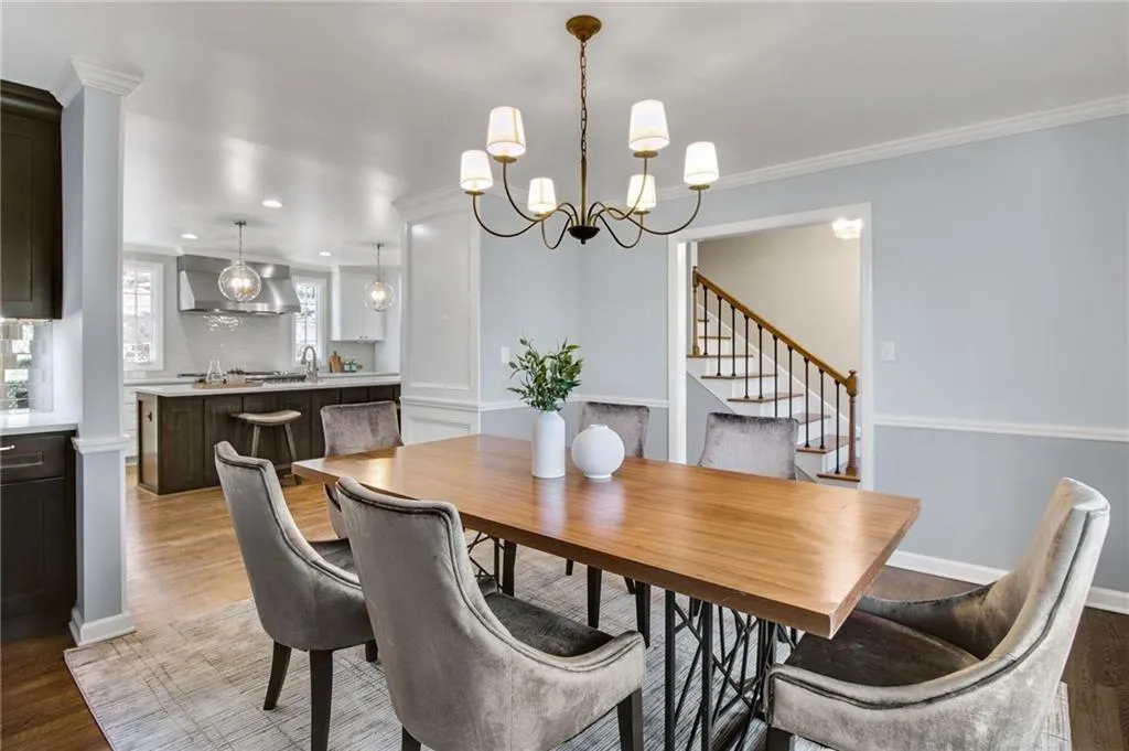 Dining room featuring an inviting chandelier, sink, crown molding, and light wood-type flooring