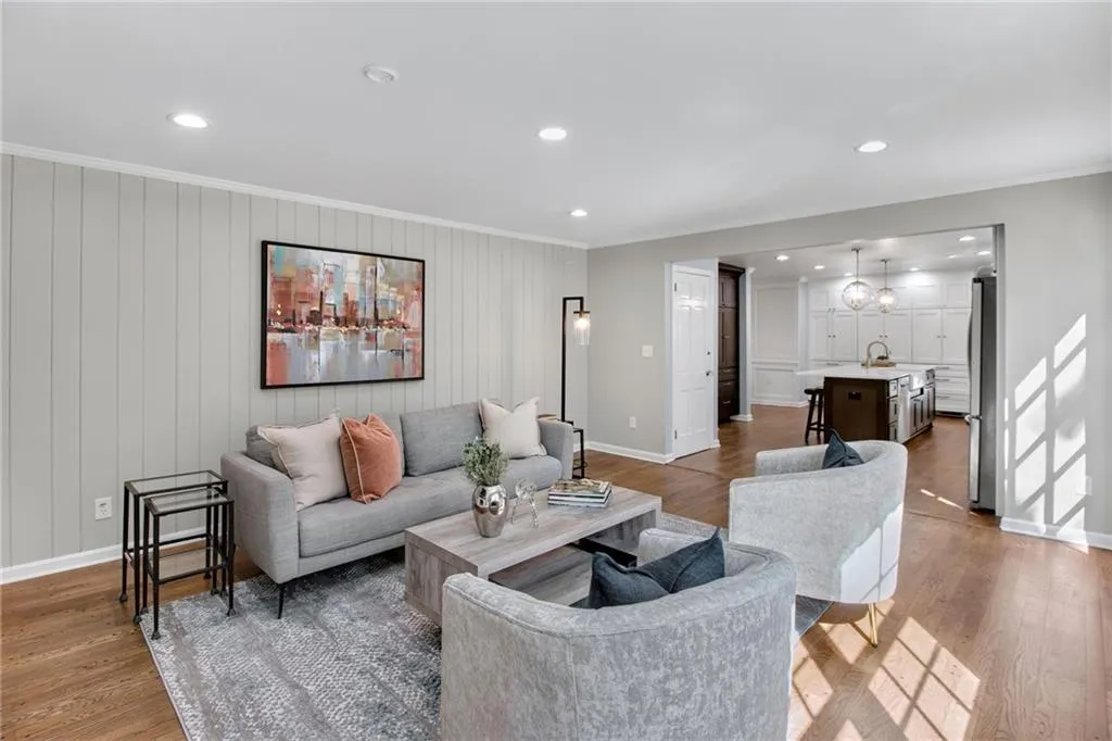 Living room featuring wood-type flooring, sink, and crown molding