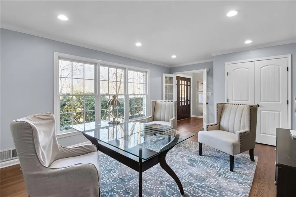 Living room with dark hardwood / wood-style flooring and crown molding
