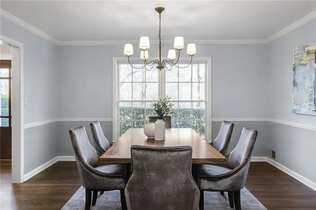 Dining space with dark hardwood / wood-style flooring, a notable chandelier, and ornamental molding