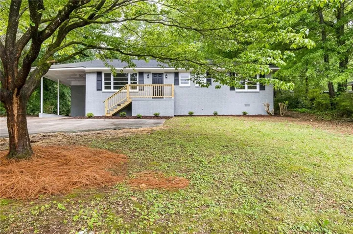 Gray exterior with white trim, black shutters, and an attached carport