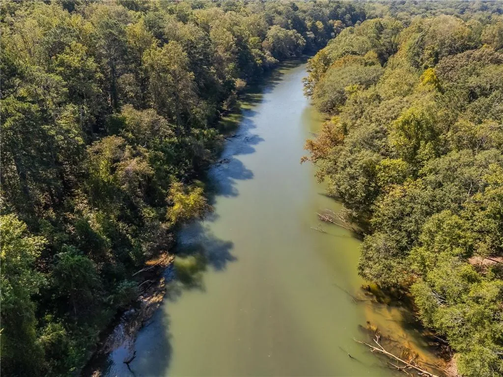 Drone / aerial view of a large body of water and a heavily wooded area