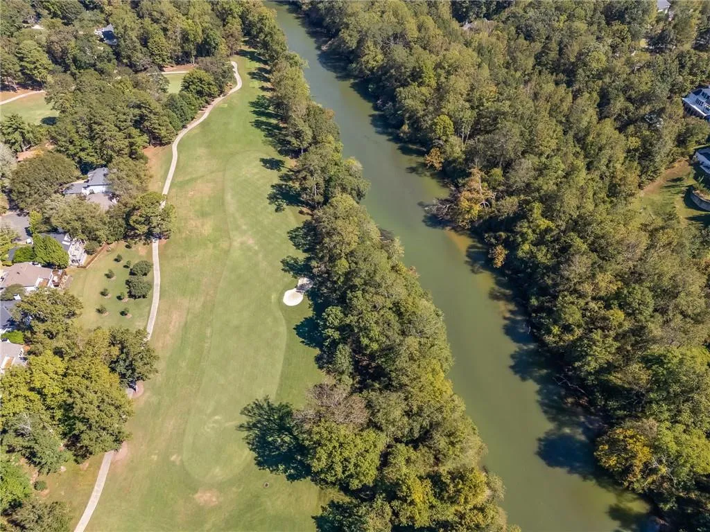 Aerial view of property's location featuring a large body of water and a golf club