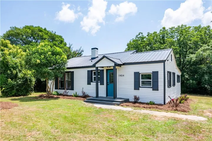 White siding exterior with a dark metal roof
