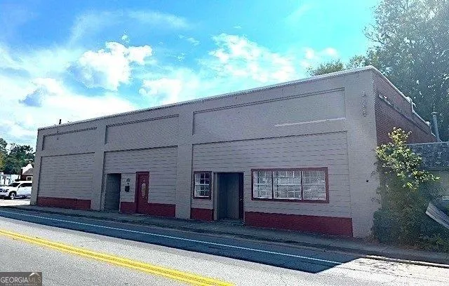 Single-story commercial building featuring a stucco exterior with a painted brick base