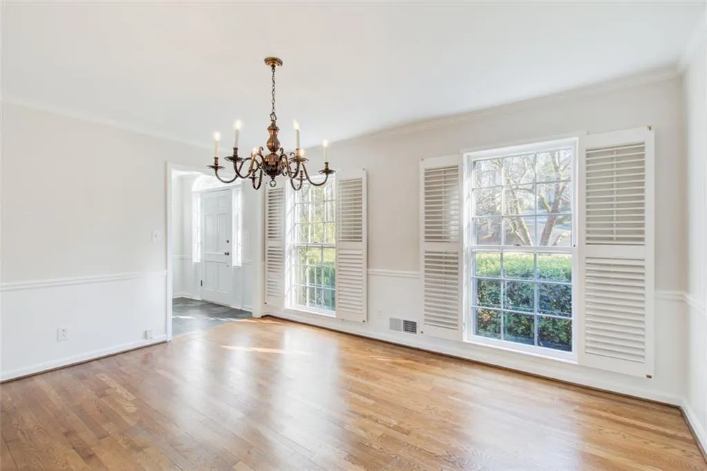 Spacious dining room with floor to ceiling windows and plantation shutters