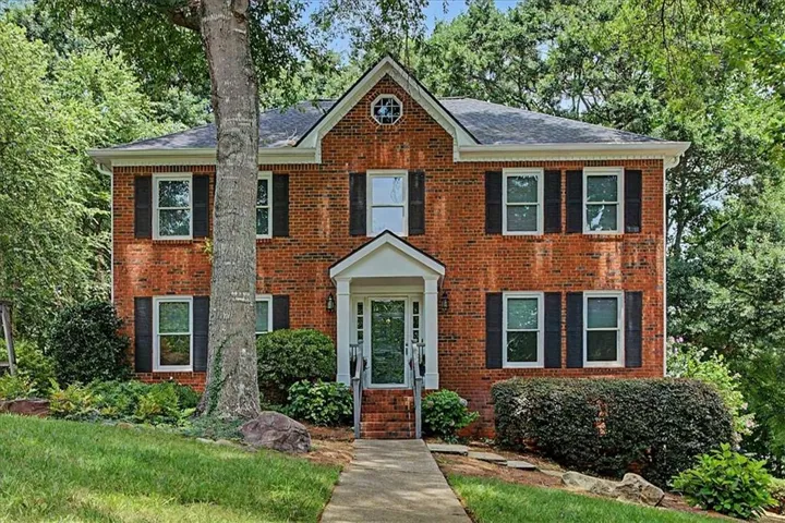 Traditional brick facade with white trim and dark window shutters