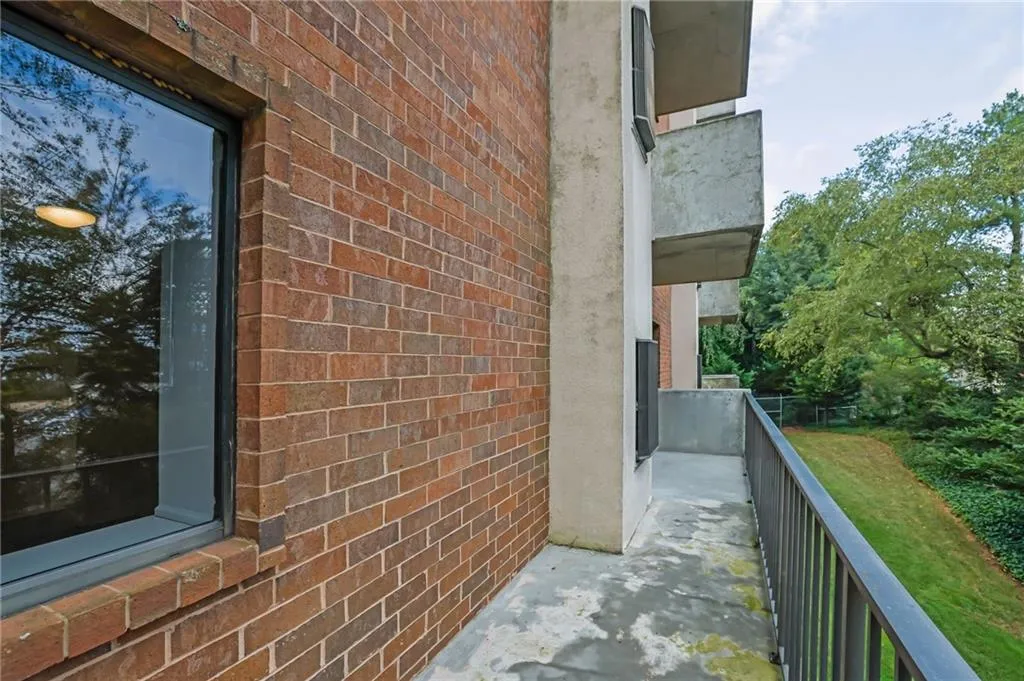 Generous balcony accessible from the living room with tree-lined view.