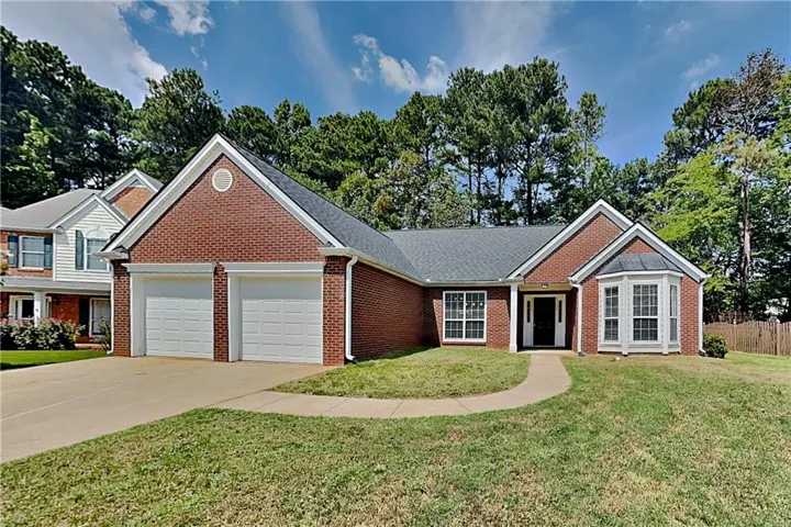 Brick exterior with a prominent two-car garage, bay window, and gabled roofline