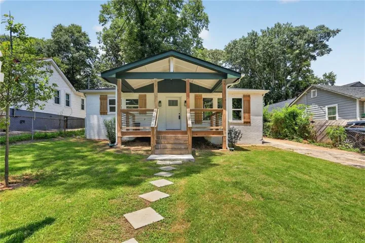 Single-story residence featuring a covered front porch with natural wood railings and support beams