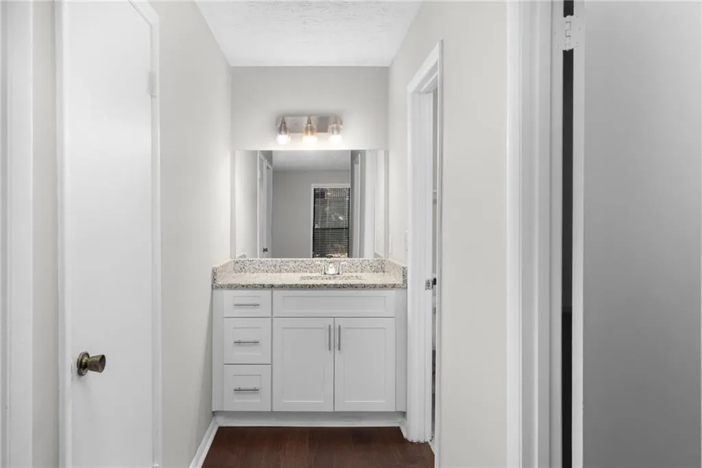 Bathroom featuring vanity, dark wood-style floors, and a textured ceiling