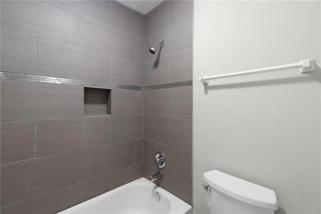 Full bathroom with shower / washtub combination and toilet