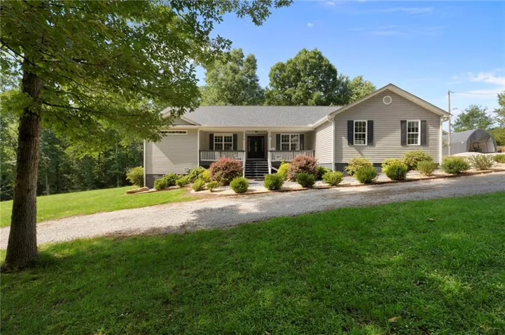 Ranch-style residence featuring light gray siding and a covered front porch