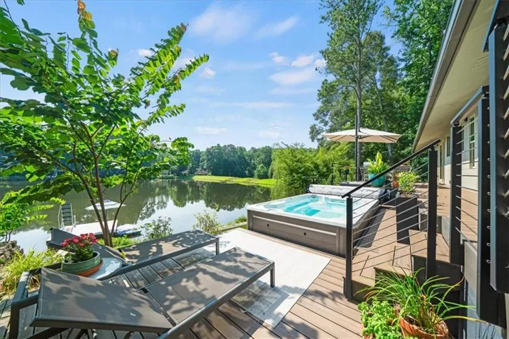 Waterfront deck featuring a built-in hot tub