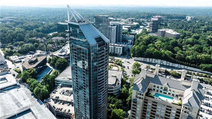 High-rise building with a distinctive pointed roofline, expansive window-clad facade, and multiple curved balconies