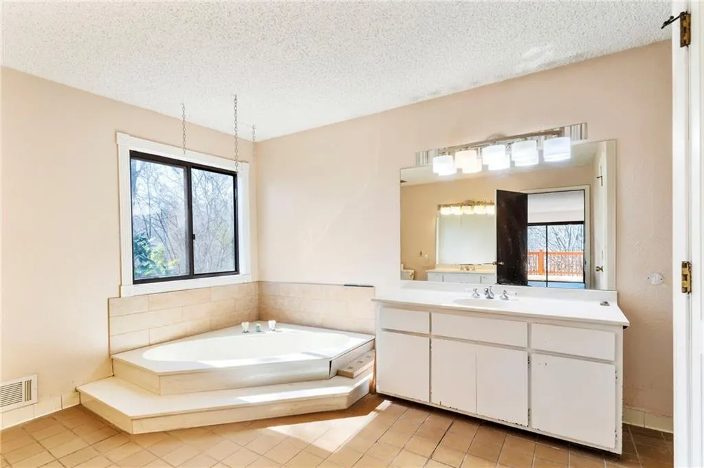 Full bathroom featuring a bath, visible vents, a textured ceiling, and vanity