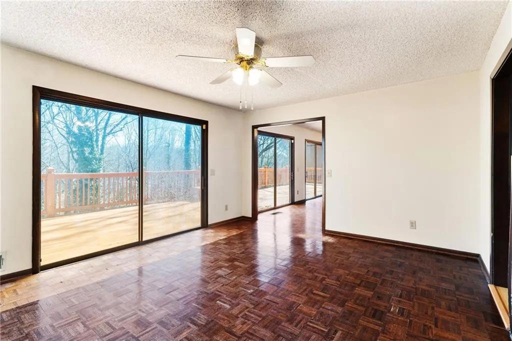 Spare room with a textured ceiling, ceiling fan, and baseboards