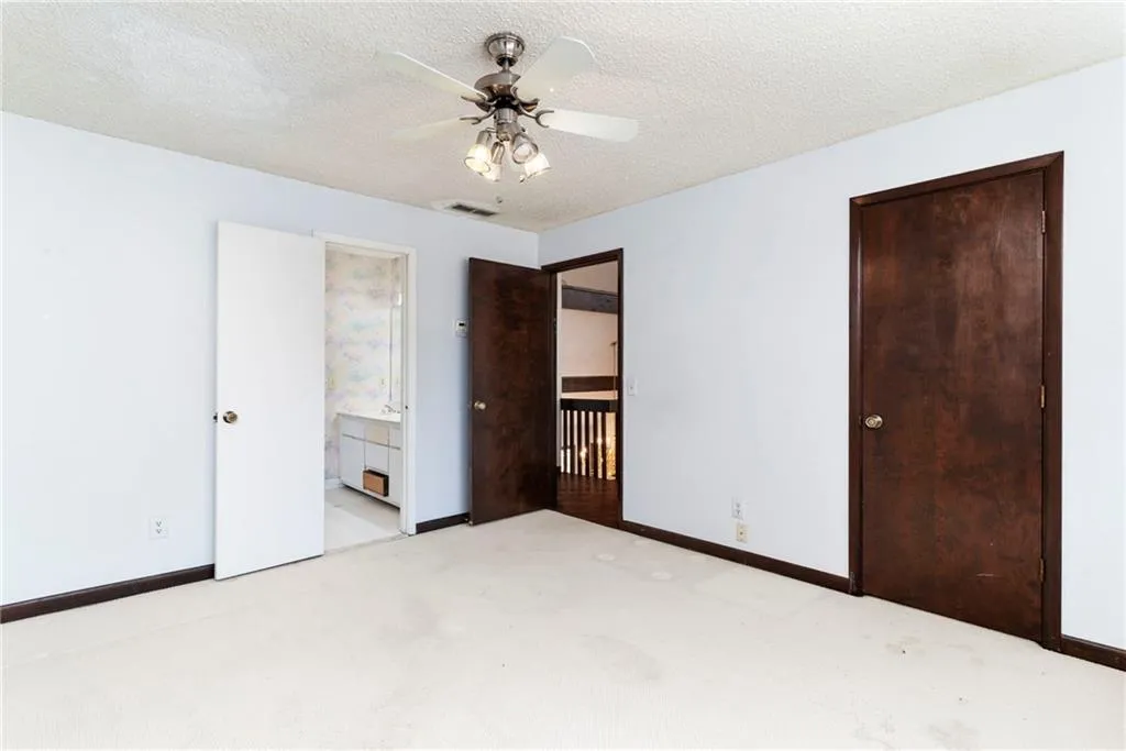 Unfurnished bedroom featuring carpet, visible vents, a textured ceiling, and baseboards