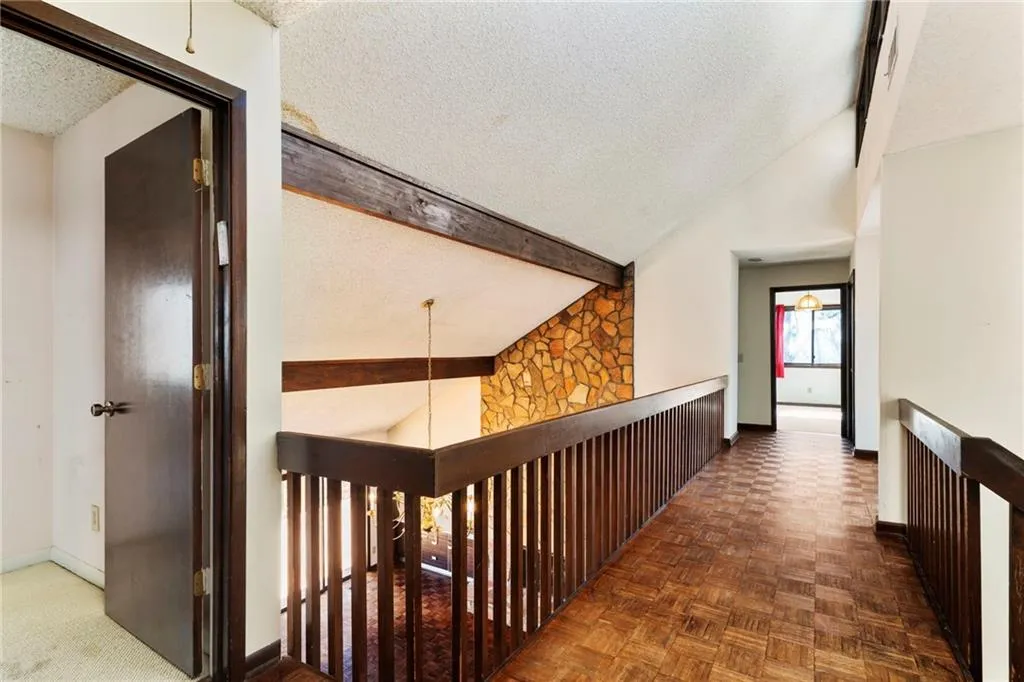 Hall featuring high vaulted ceiling, baseboards, a textured ceiling, and beamed ceiling