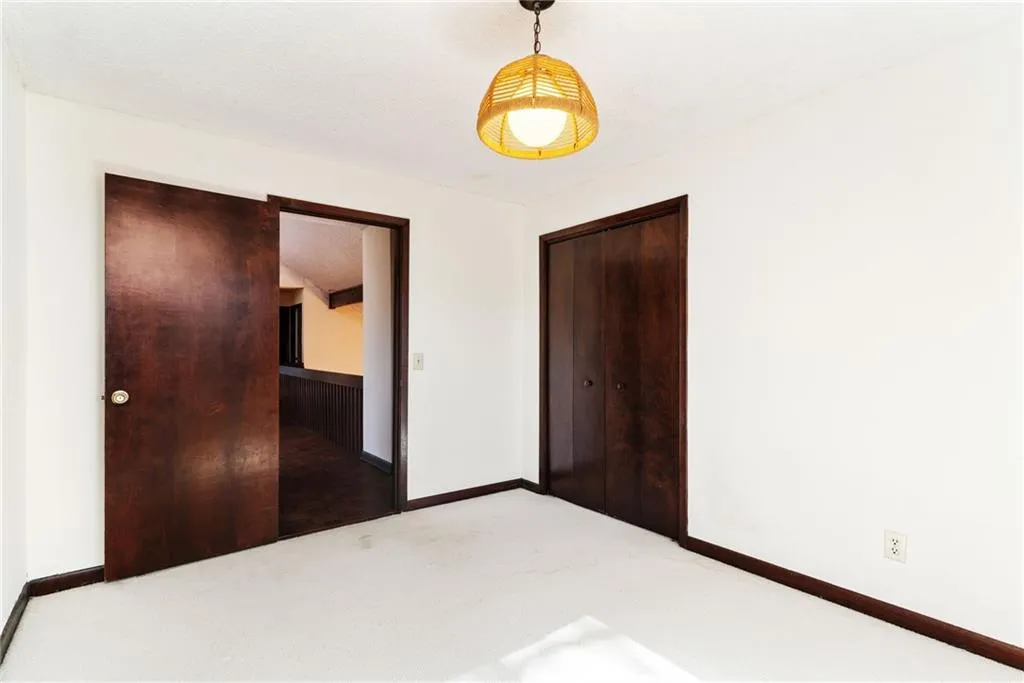 Unfurnished bedroom featuring a closet, carpet flooring, and baseboards