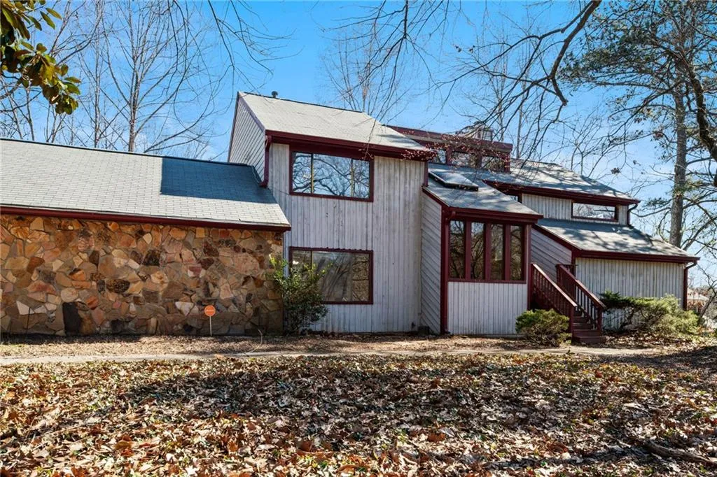 View of side of home featuring stone siding and a chimney