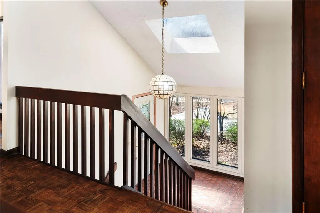 Staircase featuring lofted ceiling and an inviting chandelier