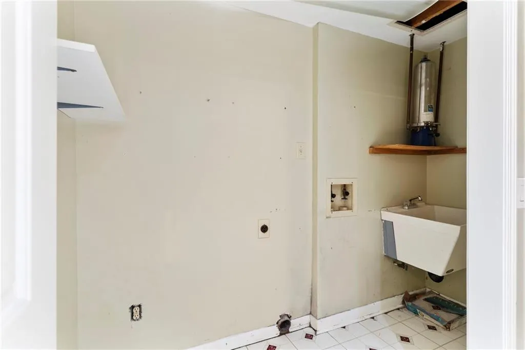 Washroom featuring washer hookup, water heater, hookup for an electric dryer, a sink, and laundry area