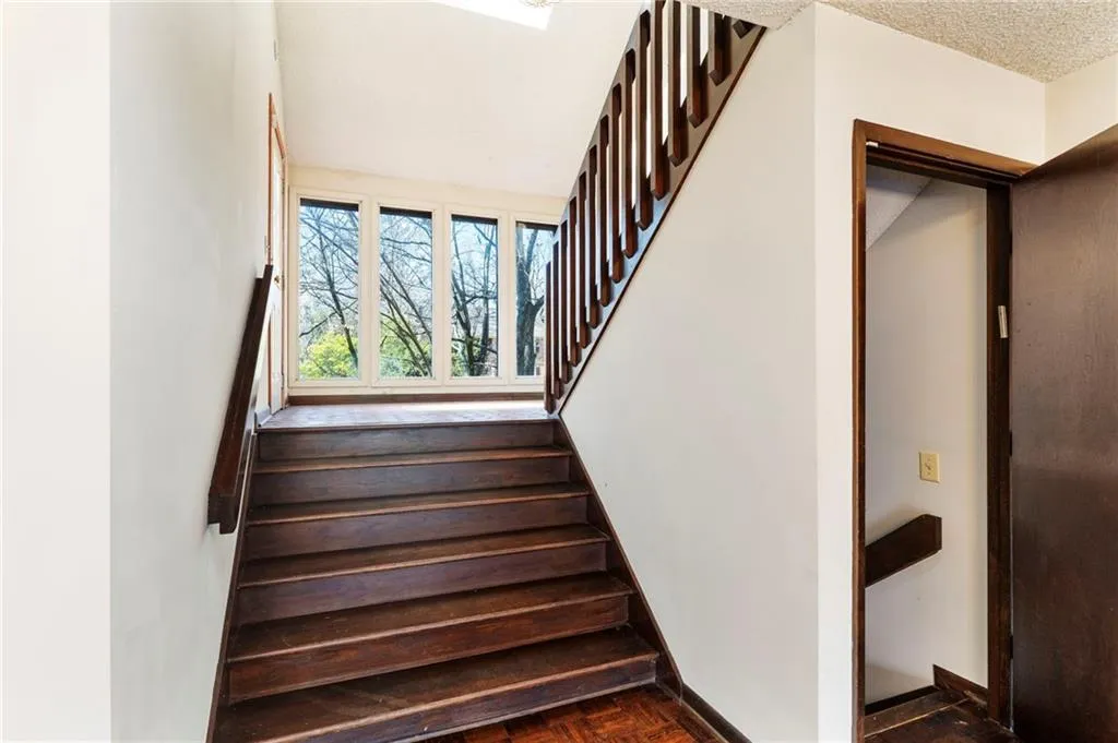 Stairs featuring a textured ceiling and baseboards