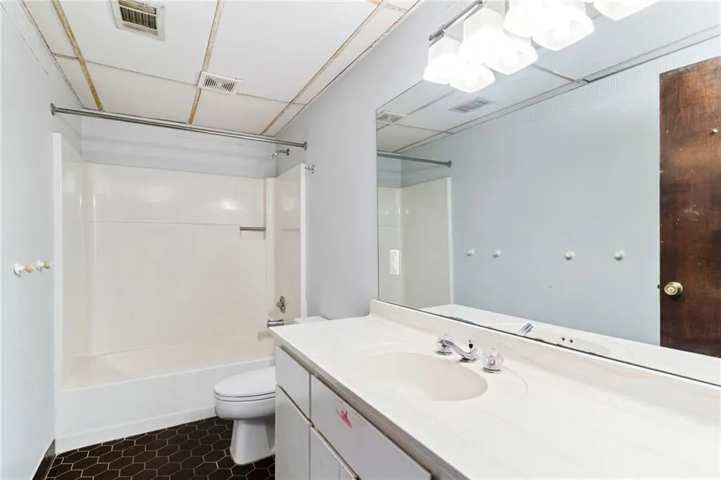 Full bath with toilet, washtub / shower combination, and visible vents