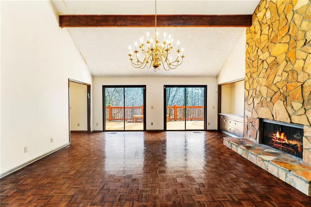 Unfurnished living room featuring a textured ceiling, high vaulted ceiling, a fireplace, and beam ceiling