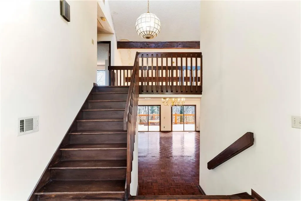 Stairs featuring a chandelier, visible vents, and a towering ceiling