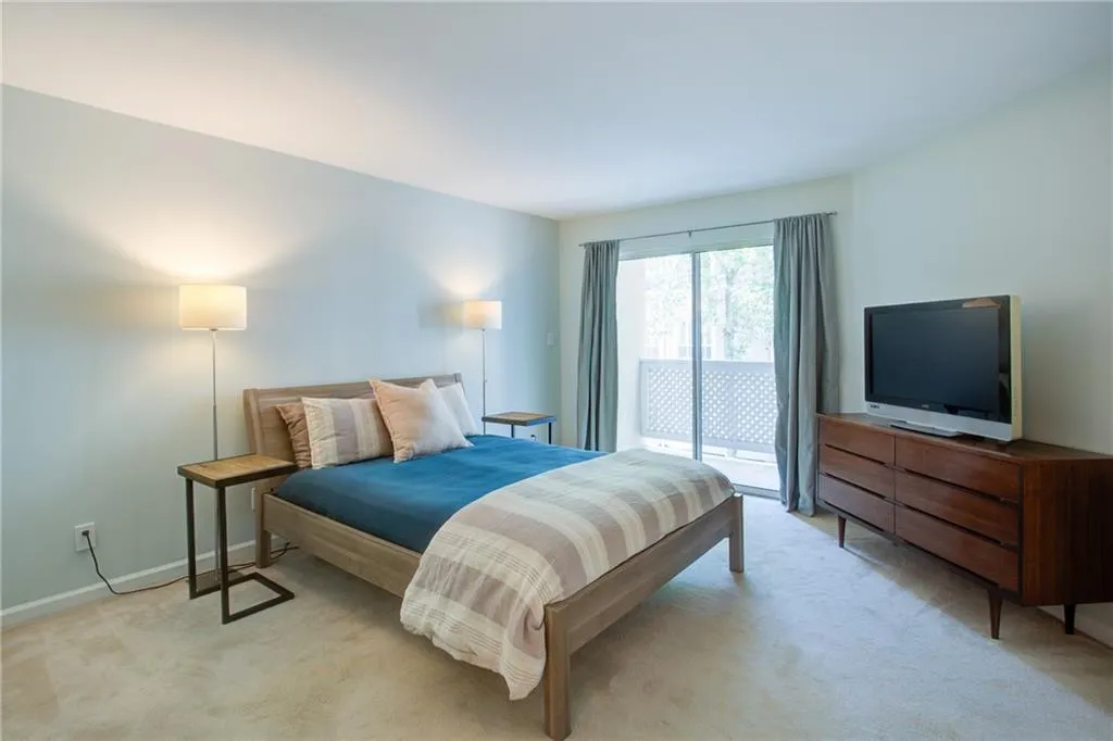 Bedroom featuring light carpet and access to exterior