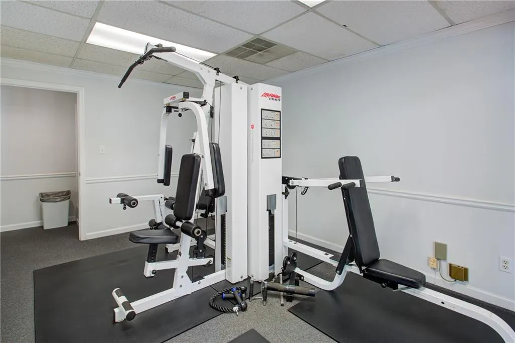 Workout room featuring a paneled ceiling and crown molding