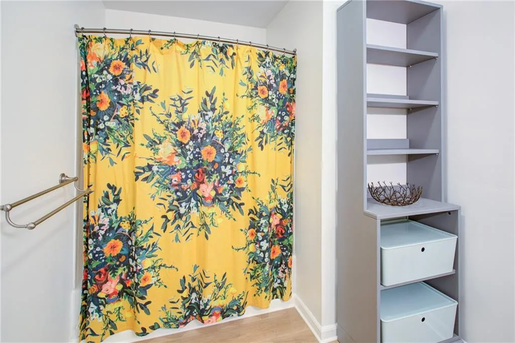 Bathroom with wood finished floors and a shower with shower curtain
