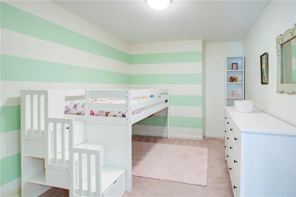 Bedroom with light colored carpet and baseboards