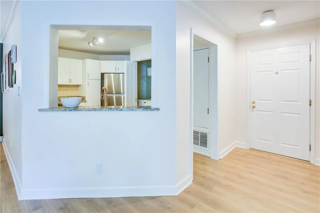 Entrance foyer featuring light wood-style floors and ornamental molding