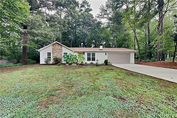 Ranch-style exterior with white siding and stone accent