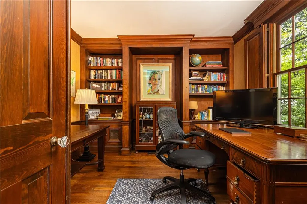 A classic office space right off the dining room boasts sophisticated wood finishes.