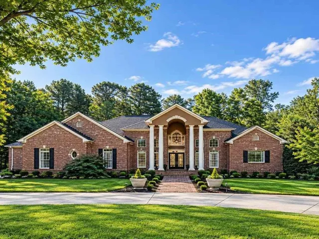 Brick exterior with a prominent portico featuring four white columns. AI-enhanced image. Some details have been digitally modified