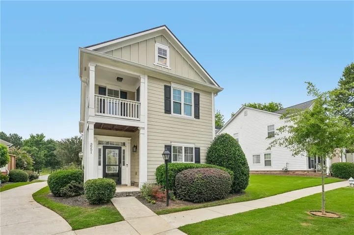 Two-story residence featuring light-colored siding and dark shutters