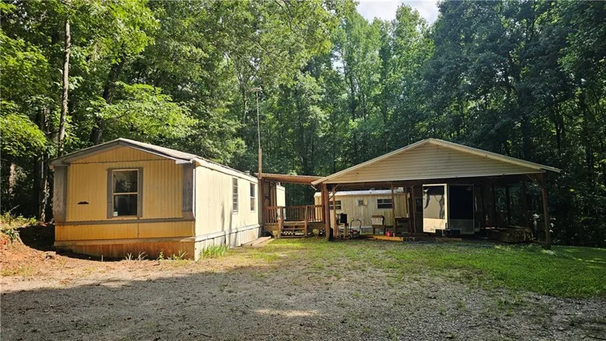 Two structures set against a wooded backdrop