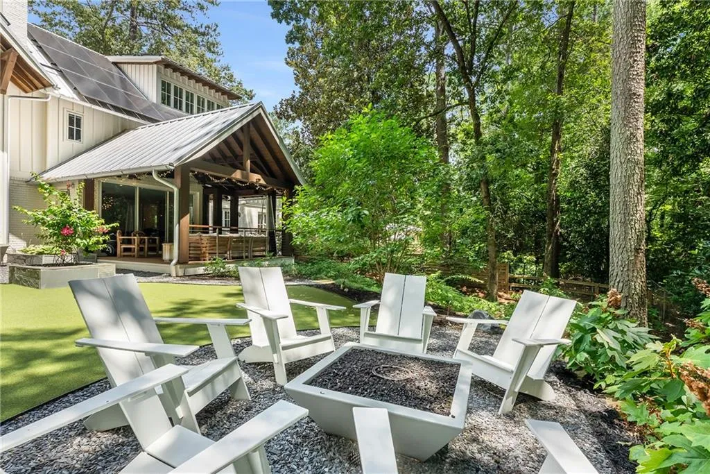 View of porch from Adirondack chair seating area with fire pit and speakers