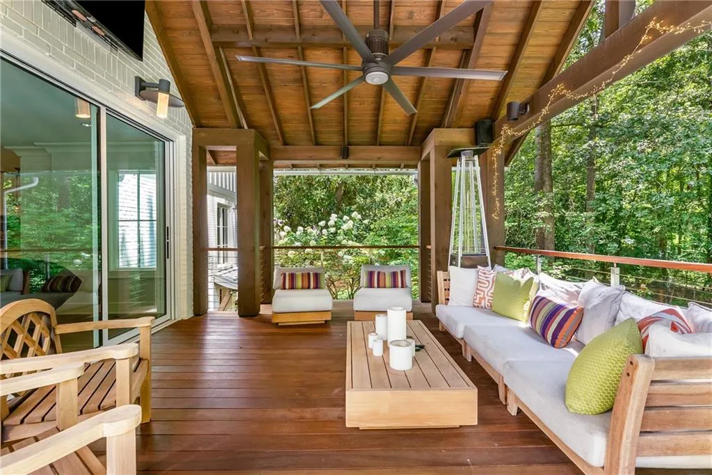 Attached covered porch with wall mounted TV, Speakers, fan, and lighting