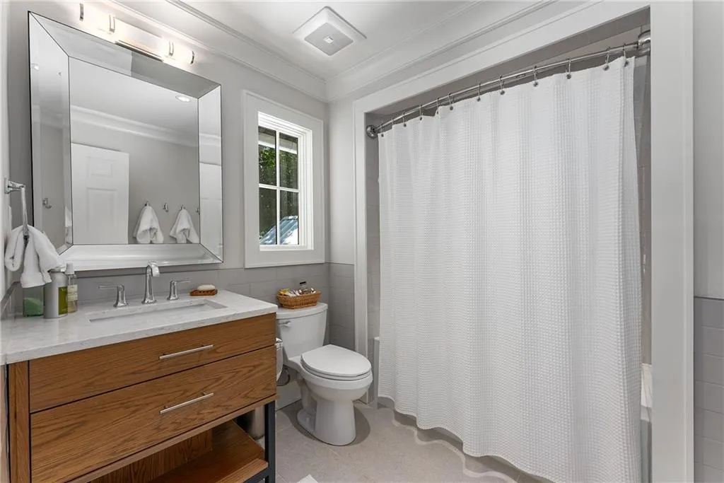 Full bathroom featuring vanity, tile walls, and crown molding
