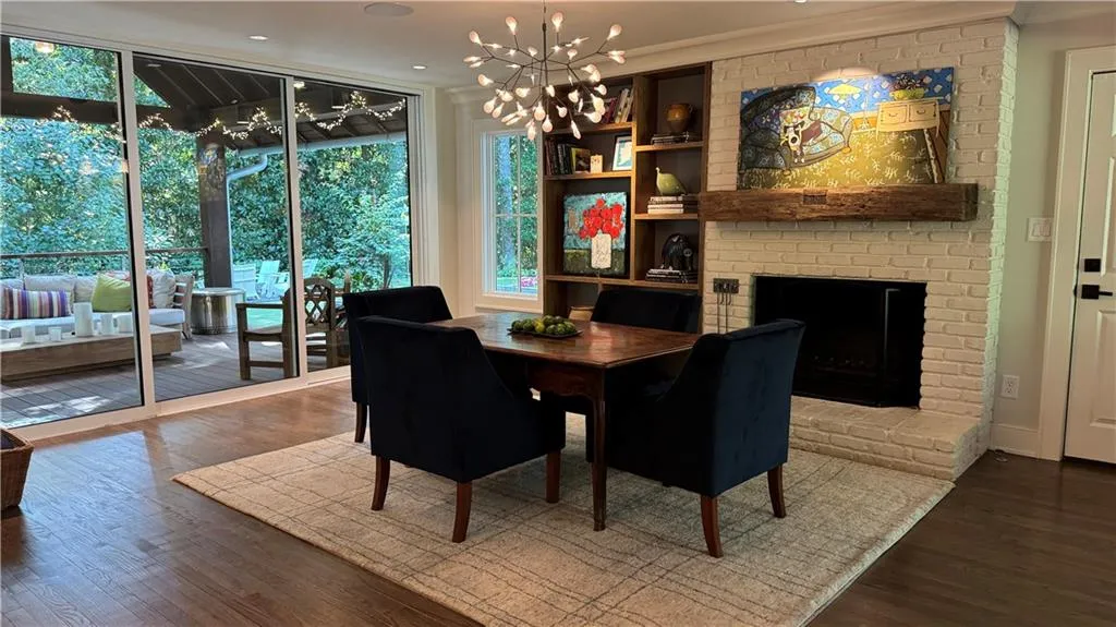 Extension of Kitchen eating area featuring a fireplace, a wall of windows, dark wood finished floors, a chandelier, and ornamental molding